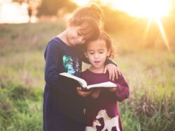 Due sorelle leggono un libro per bambini