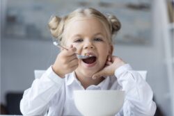 Una bambina fa colazione